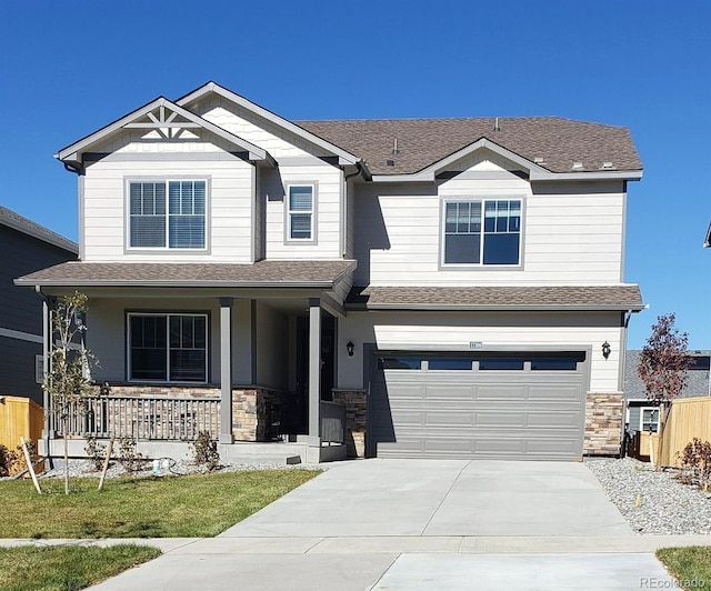 craftsman-style house with covered porch, a garage, and a front yard