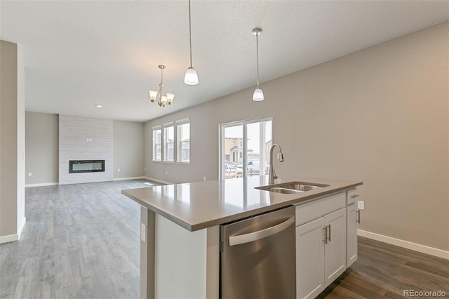 kitchen with a kitchen island with sink, sink, pendant lighting, dishwasher, and white cabinetry