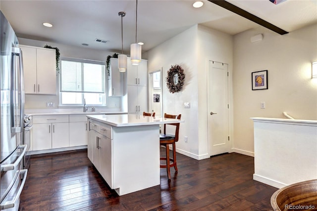 852 Kalamath St, Denver, CO 80204 - kitchen featuring freestanding refrigerator, a breakfast bar area, dark wood-style flooring, light countertops, and recessed lighting