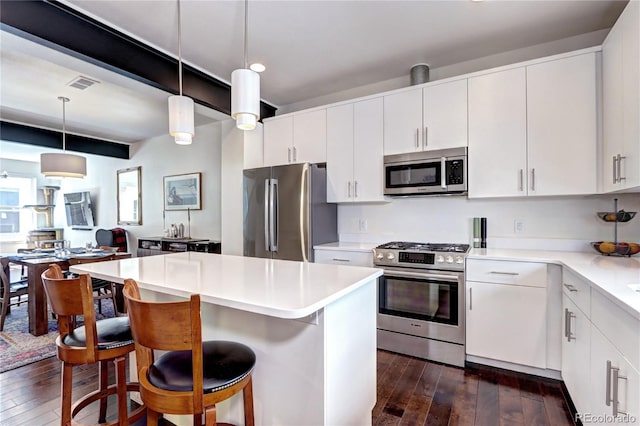 852 Kalamath St, Denver, CO 80204 - kitchen with appliances with stainless steel finishes, dark wood finished floors, a kitchen breakfast bar, a center island, and recessed lighting