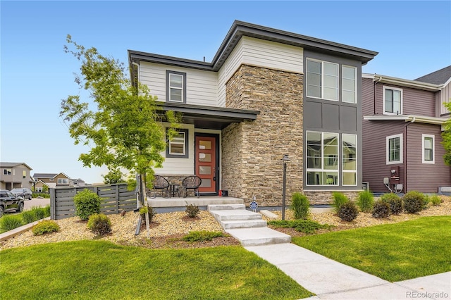 6211 Stable View St, Castle Pines, CO 80108 - view of front of home featuring stone siding, a porch, and a front yard