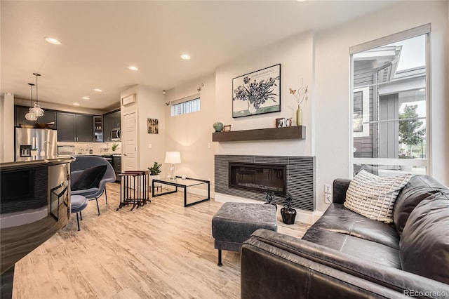 6211 Stable View St, Castle Pines, CO 80108 - living area featuring a glass covered fireplace, light wood-style flooring, and recessed lighting