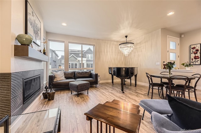 6211 Stable View St, Castle Pines, CO 80108 - living room featuring wood finished floors, a glass covered fireplace, a chandelier, and recessed lighting