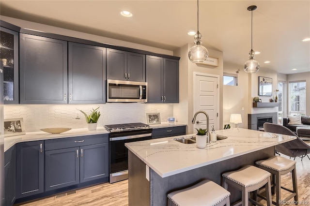 6211 Stable View St, Castle Pines, CO 80108 - kitchen featuring appliances with stainless steel finishes, light wood-style floors, a kitchen breakfast bar, and recessed lighting