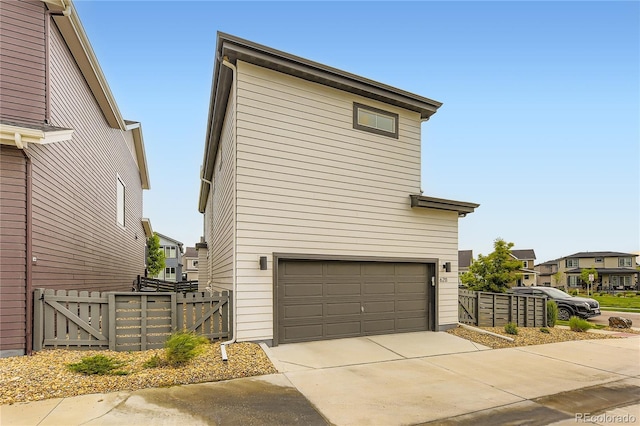 6211 Stable View St, Castle Pines, CO 80108 - view of side of property with a gate, an attached garage, driveway, and a residential view