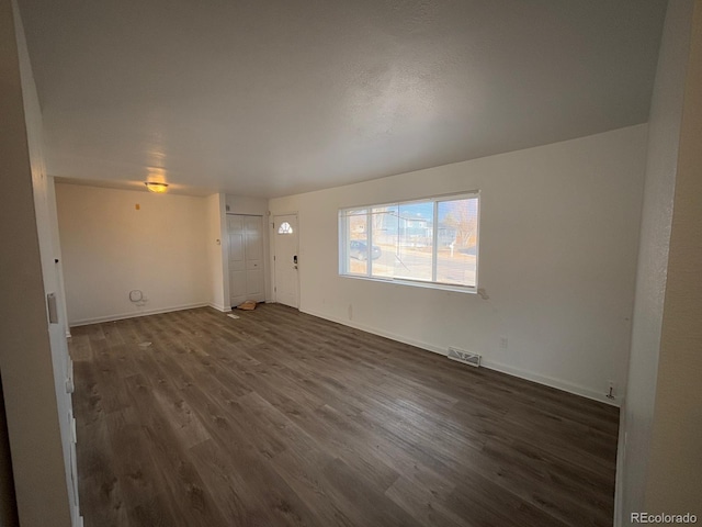 unfurnished living room featuring dark hardwood / wood-style floors