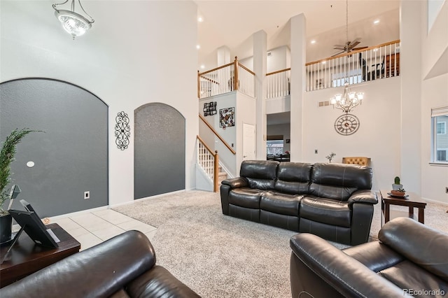 living room featuring arched walkways, a high ceiling, stairway, and carpet