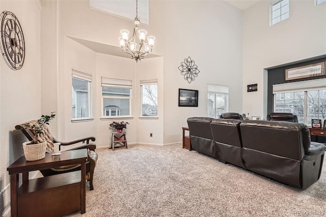 living room featuring baseboards, a high ceiling, carpet, and a notable chandelier