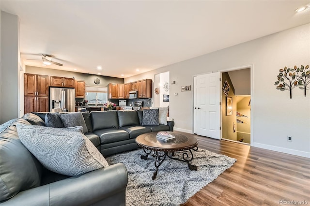 living room with light wood-style floors, baseboards, and recessed lighting