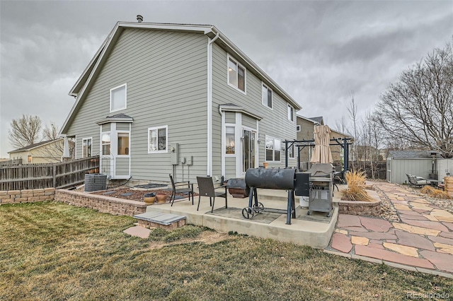 back of property featuring a storage shed, an outdoor structure, fence, a yard, and a patio area