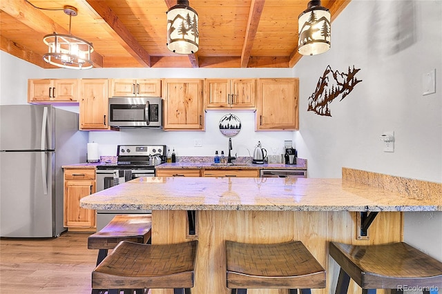 kitchen featuring beam ceiling, appliances with stainless steel finishes, and light brown cabinets