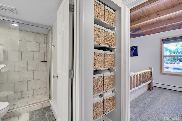 interior space featuring beam ceiling, wooden ceiling, toilet, tiled shower, and tile patterned floors