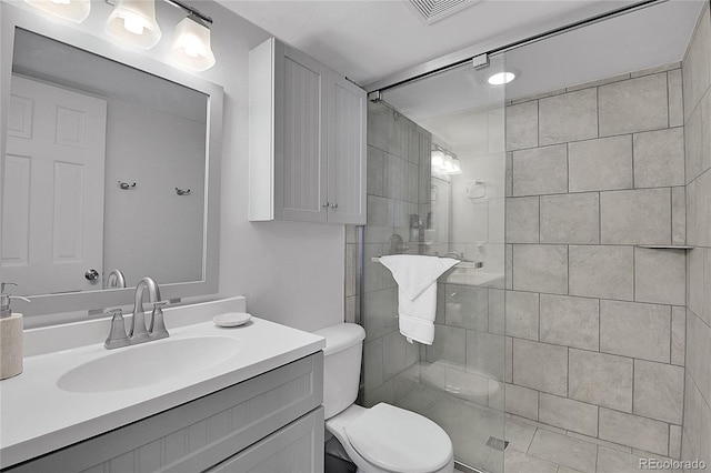 bathroom with toilet, an enclosed shower, and vanity