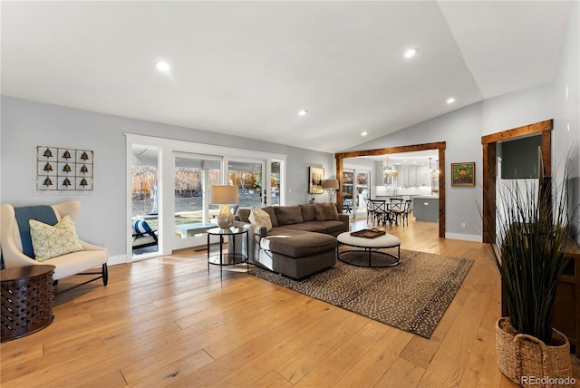 living area with recessed lighting, baseboards, lofted ceiling, and light wood finished floors