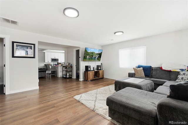 living room with visible vents and wood finished floors