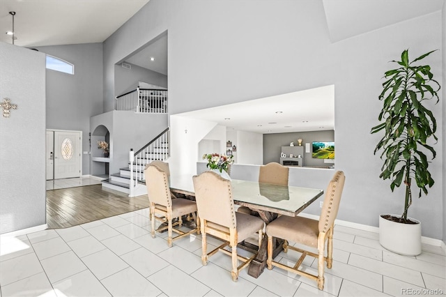 dining room featuring a towering ceiling and light hardwood / wood-style flooring