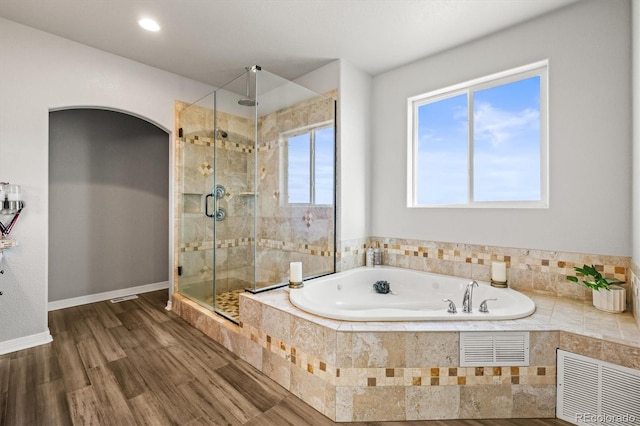 bathroom with hardwood / wood-style floors and shower with separate bathtub