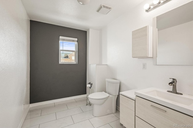 bathroom featuring tile patterned floors, vanity, and toilet