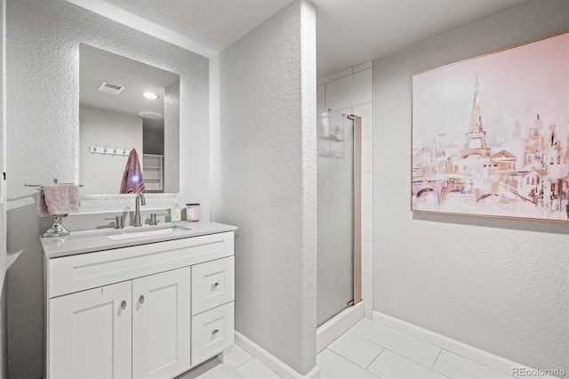 bathroom featuring tile patterned flooring, vanity, and a shower with shower door