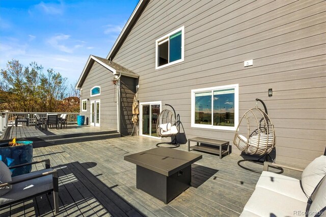 deck with an outdoor living space with a fire pit