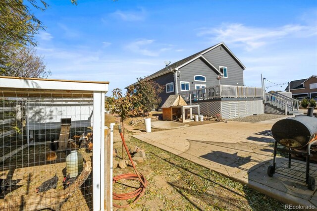 back of property featuring a patio area and a deck