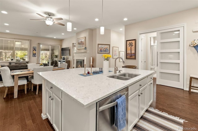 3418 New Haven Cir, Castle Rock, CO 80109 - kitchen with stainless steel dishwasher, a sink, open floor plan, white cabinets, and dark wood-style flooring
