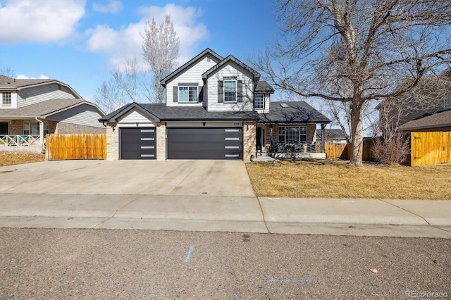 view of front of home with a garage, brick siding, fence, and driveway