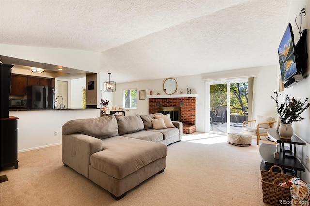 carpeted living room with sink, vaulted ceiling, a brick fireplace, and a textured ceiling