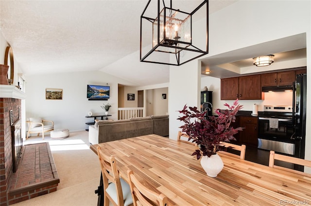 carpeted dining room featuring lofted ceiling, a textured ceiling, and a fireplace