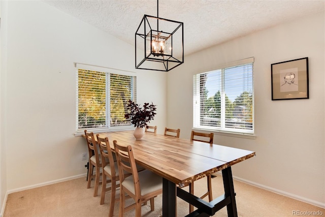 carpeted dining room with vaulted ceiling, a textured ceiling, a chandelier, and plenty of natural light