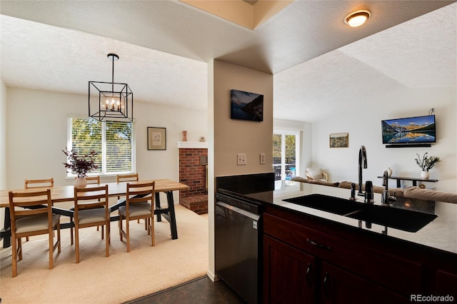 kitchen featuring sink, dishwasher, hanging light fixtures, light carpet, and lofted ceiling