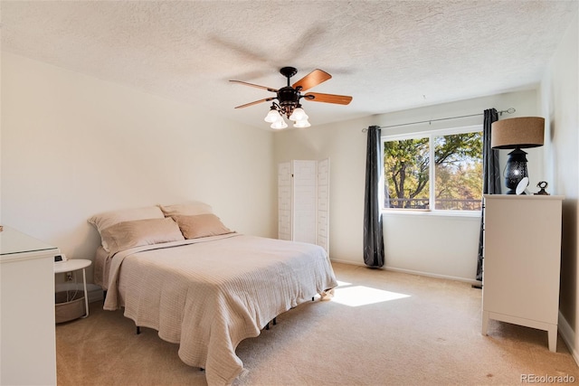 bedroom with ceiling fan, a textured ceiling, and light colored carpet