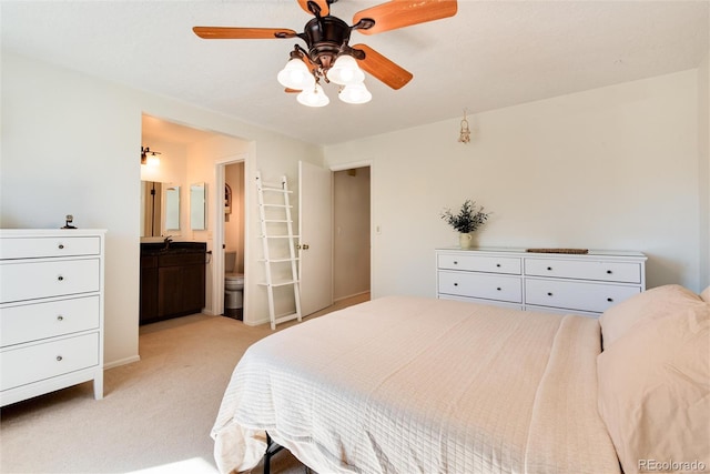 bedroom with sink, ensuite bathroom, light colored carpet, and ceiling fan