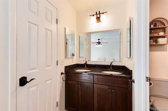 bathroom featuring toilet, vanity, and ceiling fan