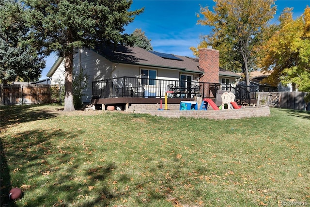 back of house featuring a wooden deck and a yard