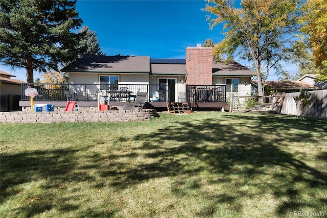 rear view of property with a wooden deck and a yard