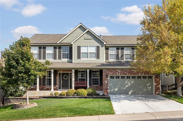 view of front of property with a front yard, a garage, and a porch