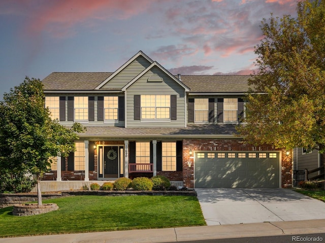 view of front facade featuring covered porch, a garage, and a yard