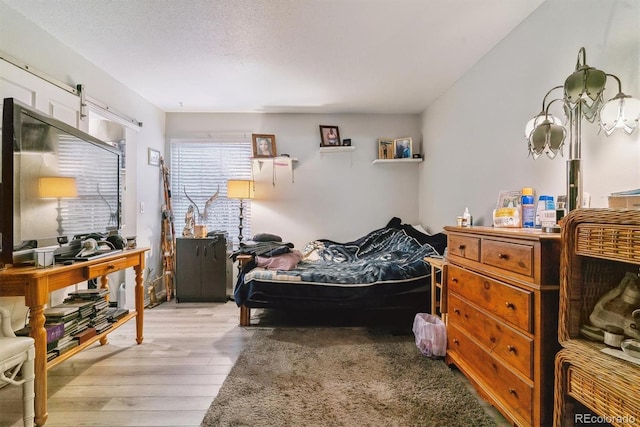 bedroom featuring a textured ceiling and wood finished floors