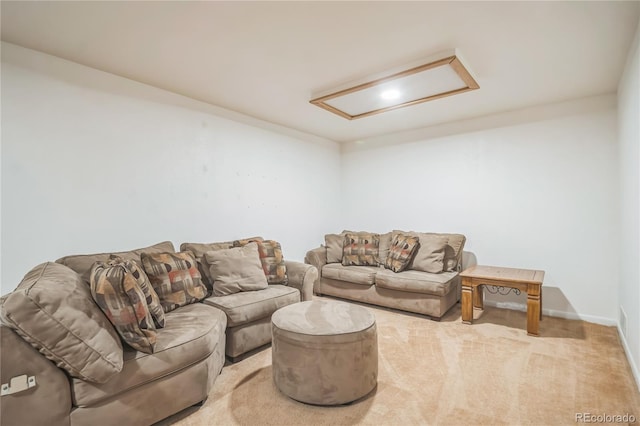 carpeted living area with baseboards and attic access