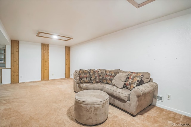 living area with baseboards, visible vents, light carpet, and attic access