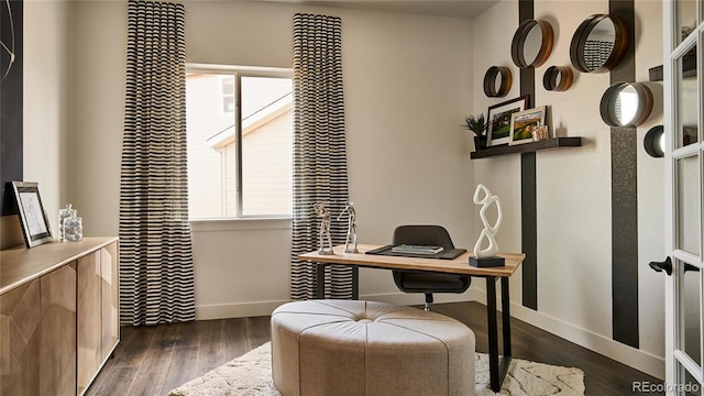 home office with plenty of natural light and dark hardwood / wood-style flooring