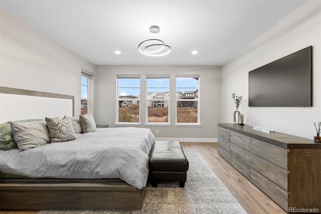 bedroom with light wood-type flooring and multiple windows