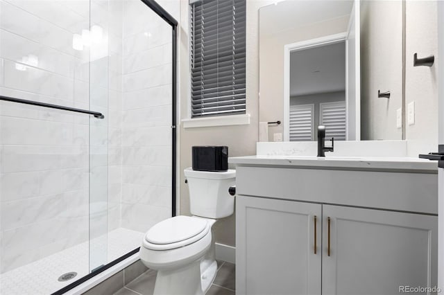 bathroom featuring toilet, tile patterned floors, walk in shower, and vanity