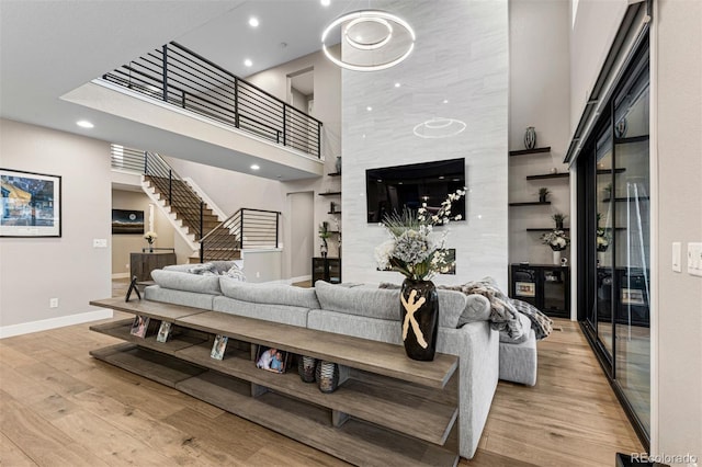 living room with a high ceiling and light hardwood / wood-style flooring