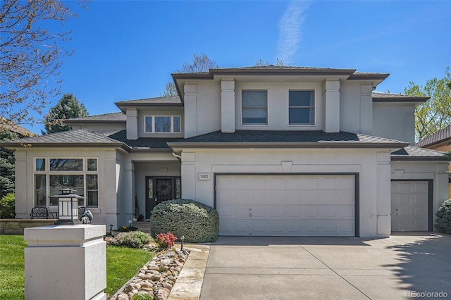 3002 S Oak Way, Lakewood, CO 80227 - prairie-style house with stucco siding, concrete driveway, an attached garage, and roof with shingles