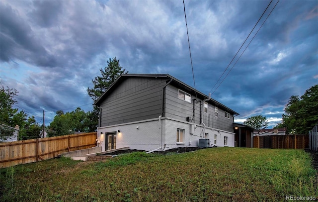 view of side of property featuring a lawn and central air condition unit