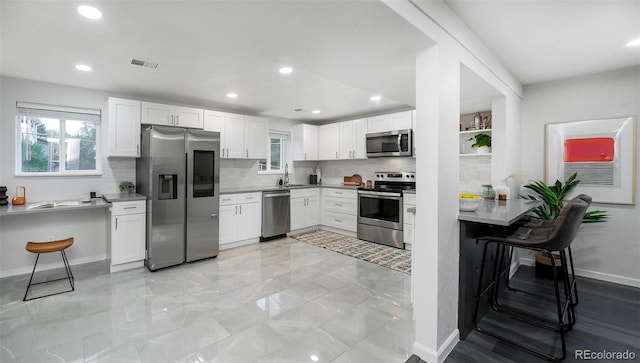 kitchen featuring sink, appliances with stainless steel finishes, and white cabinetry