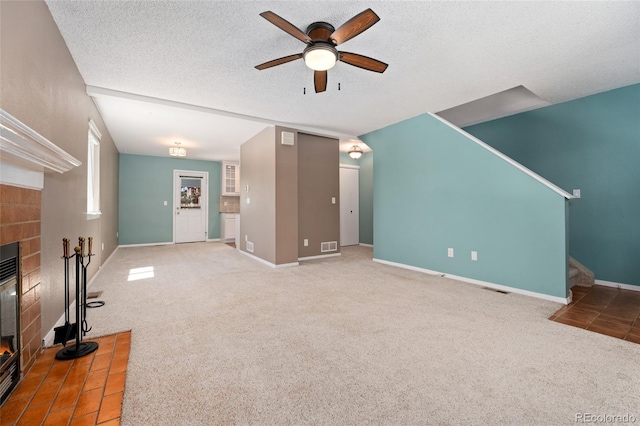 411 S Cody Ct, Lakewood, CO 80226 - unfurnished living room featuring a fireplace, ceiling fan, stairs, carpet floors, and a textured ceiling