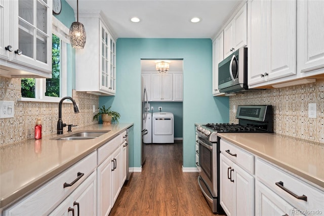 411 S Cody Ct, Lakewood, CO 80226 - kitchen featuring appliances with stainless steel finishes, a sink, washer / clothes dryer, white cabinetry, and dark wood-style flooring